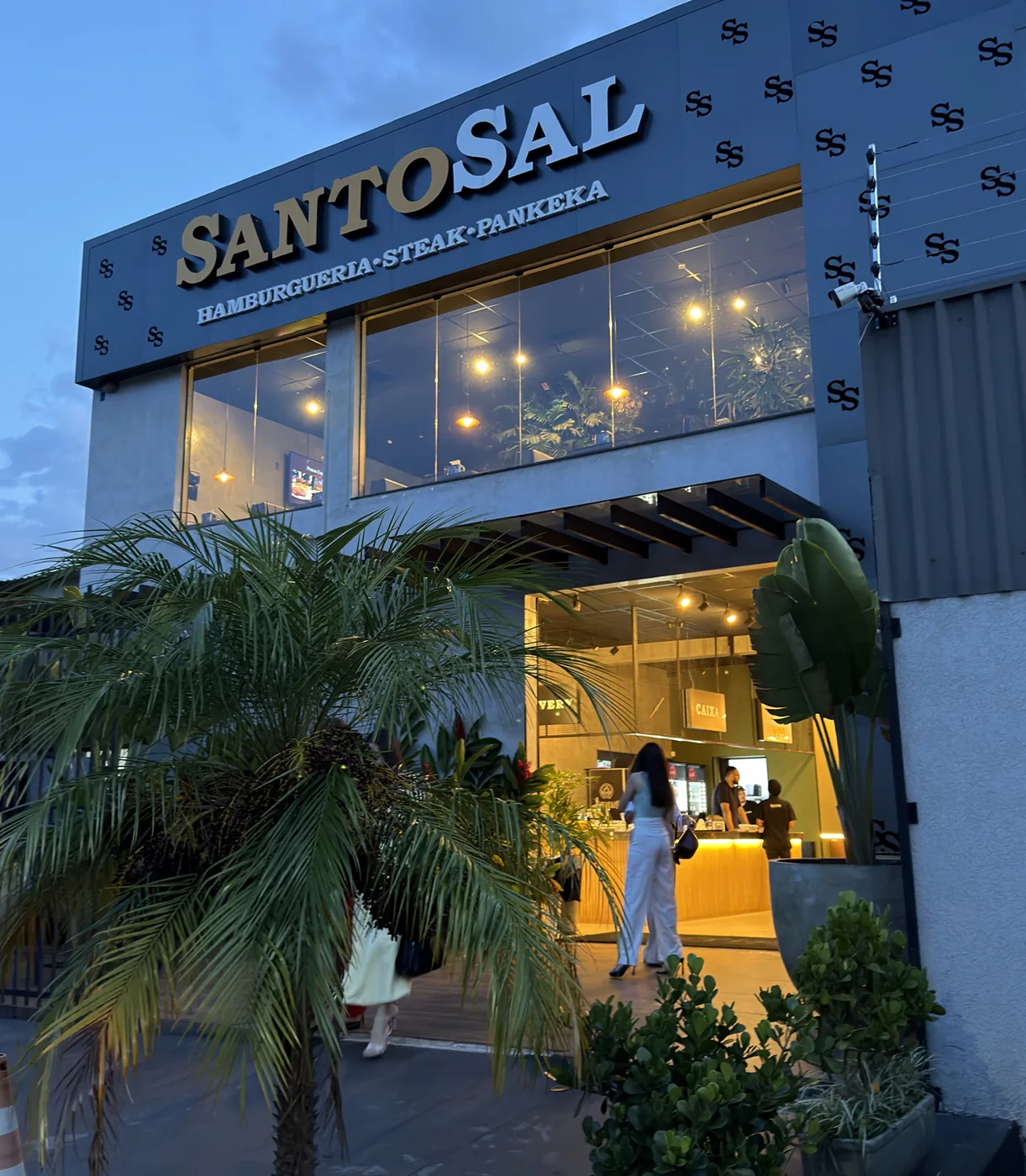 Fachada oficial da Santo Sal, com entrada térrea, janelas no pavimento superior e plantas